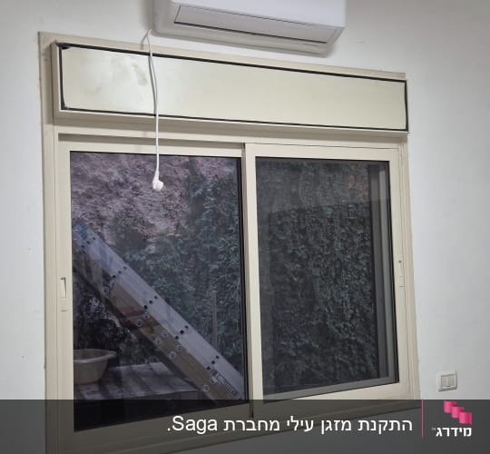 מזגן מותקן מעל חלון בחדר